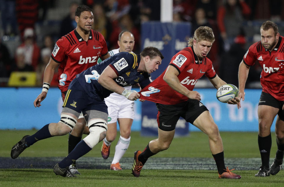 Crusaders Jack Goodhue is tackled by Highlanders Liam Squire as he makes a run upfield during the Super Rugby quarterfinal between the Crusaders and the Highlanders in Christchurch, New Zealand, Friday, June 21, 2019. (AP Photo/Mark Baker)