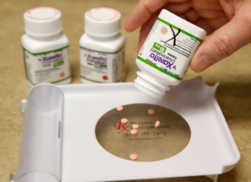 FILE PHOTO: A pharmacist dispenses pills of Xarelto, marketed by Janssen Pharmaceutica, at a pharmacy in Provo
