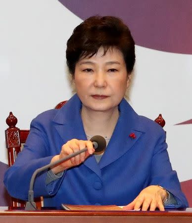 South Korean President Park Geun-hye adjusts a microphone during an emergency cabinet meeting at the Presidential Blue House in Seoul, South Korea, December 9, 2016. Yonhap/ via REUTERS