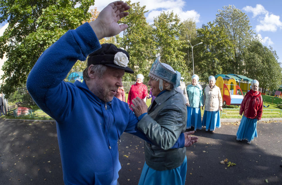 People dance near a poling station during Leningrad region's governor and municipal elections, in Luppolovo village, outside St. Petersburg, Russia, Sunday, Sept. 13, 2020. Leningrad region is the territory surrounding St. Petersburg. Elections are being held to choose governors and legislators in about half of Russia's regions. (AP Photo/Dmitri Lovetsky)