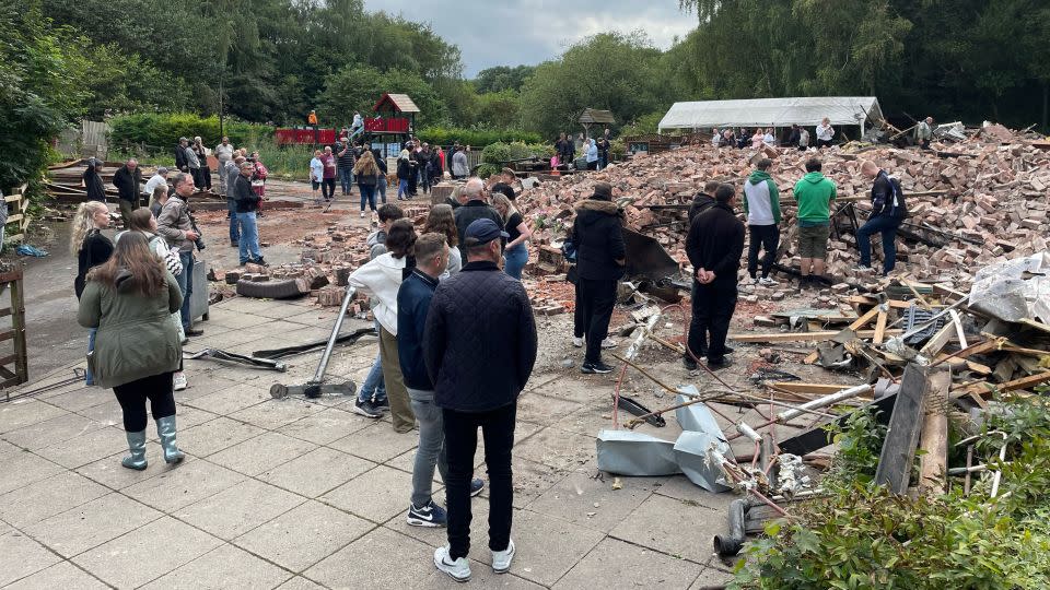 People inspect the rubble as they gather at The ruins of The Crooked House pub. - Matthew Cooper/PA Images/Getty Images