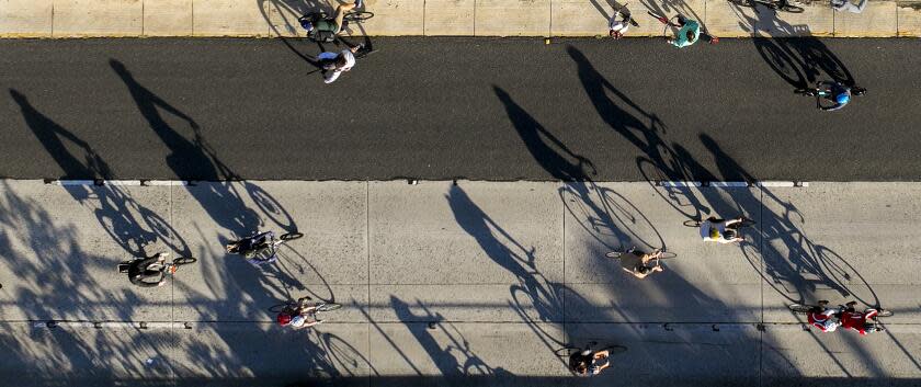 An aerial view of early morning light casting shadows of bicyclists taking part in ArroyoFest