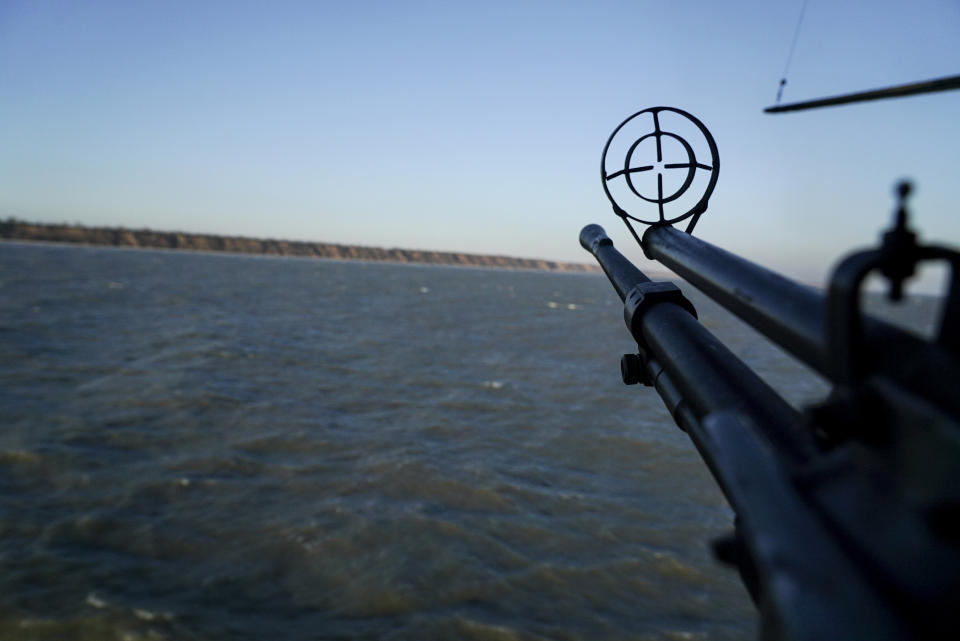 A helicopter's machine gun is turned toward the sea shore during patrol near Urzuf, south coast of Azov sea, eastern Ukraine, Thursday, Nov. 29, 2018. Ukraine put its military forces on high combat alert and announced martial law this week after Russian border guards fired on and seized three Ukrainian ships in the Black Sea. (AP Photo/Evgeniy Maloletka)