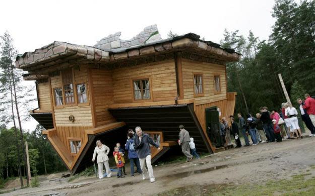 Una cola de visitantes espera para<b> visitar una casa al revés, construida en el Centro de Educación y Promoción</b> en el pueblo de Szymbark, al norte de Polonia. (REUTERS/Peter Andrews).