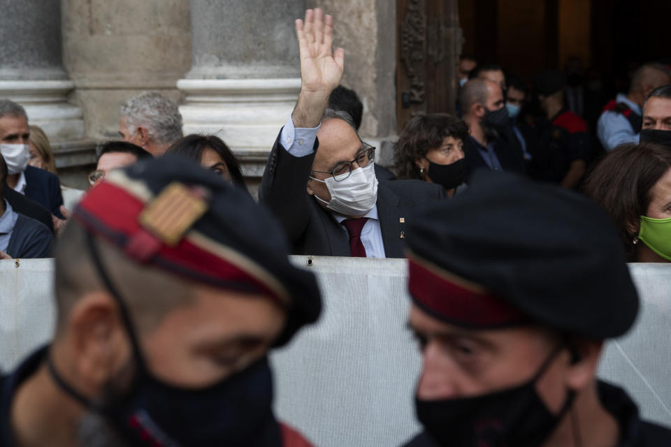 Catalonia's outgoing regional president, Quim Torra, waves to the crowd before leaving the Generalitat Palace in Barcelona, Spain on Monday, Sept. 28, 2020. Spain's Supreme Court has barred Catalonia's regional president from his office for refusing to remove a banner calling for the release of separatist leaders from prison that was displayed on a public building ahead of the 2019 general election (AP Photo/Emilio Morenatti)