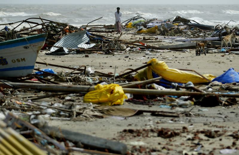 FILE PHOTO: An Indian man walks among debris left behind by a tsunami that hit Velankani beach