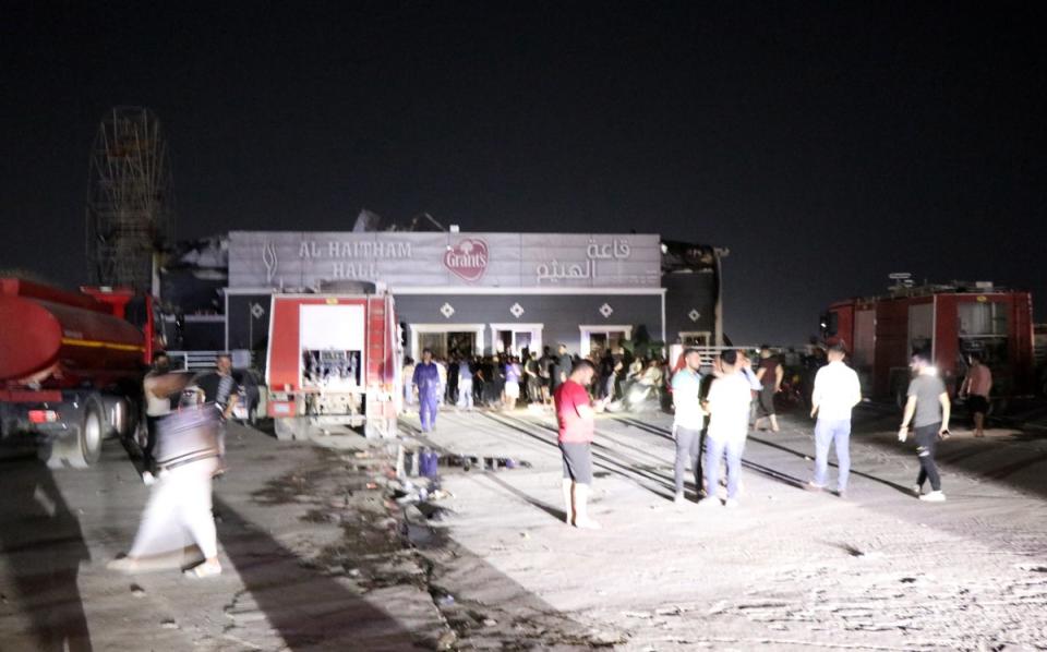 People gather outside at the scene of a fire that broke out at a wedding hall in Hamdaniya, in Iraq’s Nineveh province, north of Iraq, 27 September 2023 (EPA)