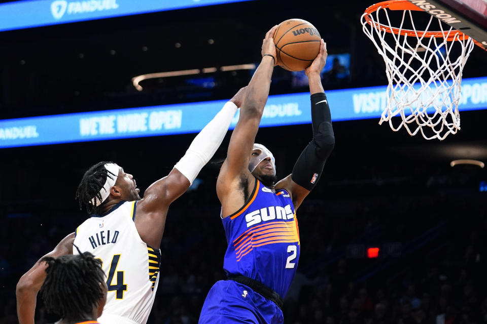 Phoenix Suns' Josh Okogie (2) goes to the basket against Indiana Pacers' Buddy Hield (24) during the second half of an NBA basketball game in Phoenix, Saturday, Jan. 21, 2023. (AP Photo/Darryl Webb)