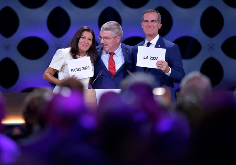 International Olympic Committee President Thomas Bach (C) poses for pictures with Paris Mayor Anne Hidalgo (L) and Los Angeles Mayor Eric Garcetti on September 13, 2017