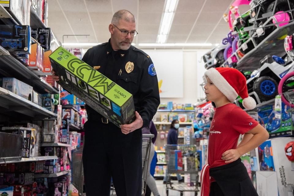 New Britain Township Police Chief Richard Clowser holds up a scooter while Alex Hershman, 8, of Doylestown, considers his options during Plumstead Township Police Department's 5th annual Shop with a Cop event at Walmart in Hilltown Township on Tuesday, December 8, 2021. Funded by community donations, the program paired law enforcement officers from 11 local departments with more than 100 kids to help them shop for presents for themselves and their families.