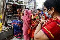 FILE- In this Saturday, Oct. 17, 2020, file photo, Hindu women, some wearing face masks to prevent the spread of the coronavirus, perform rituals outside a temple in Kolkata, India. Weeks after India fully opened up from a harsh lockdown and began to modestly turn a corner by cutting new infections by near half, a Hindu festival season is raising fears that the disease could spoil the hard-won gains. Health experts worry the festivals can set off a whole new cascade of infections, further testing and straining India’s battered health care system. (AP Photo/Bikas Das, File)