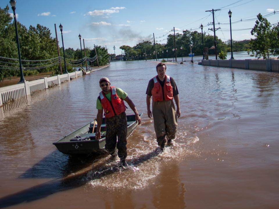 United States Geological Survey workers push a boat as they look for residents on a street flooded as a result of the remnants of Hurricane Ida in Somerville, NJ., Thursday, Sept. 2, 2021.