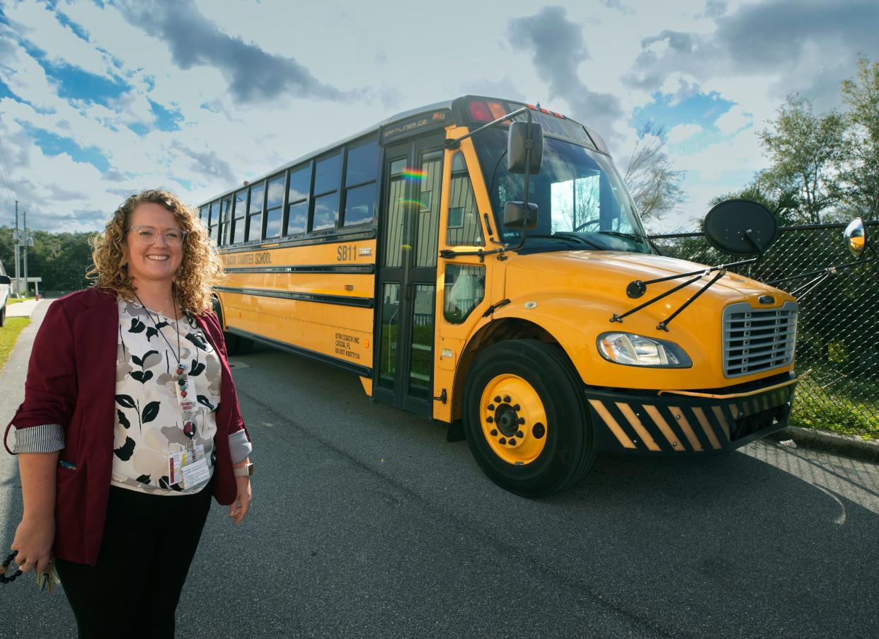 Ivy Hawn Charter School Principal Danielle Suhr with the facility's only bus at the school in Lake Helen, Tuesday, Oct. 24, 2023.