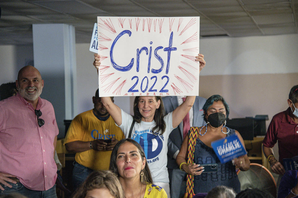 Charlie Crist supporter Sandy Moise holds sign as U.S. Rep. Charlie Crist announces his running mate Karla Hernández-Mats at Hialeah Middle School in Hialeah, Fla., Saturday Aug. 27, 2022 as he challenges Republican Gov. Ron DeSantis in November (AP Photo/Gaston De Cardenas)