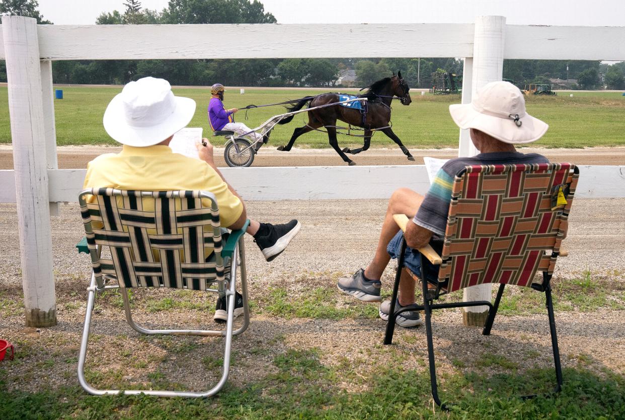 Mike Williams and Tom Wood watch the harness races Monday on the opening day of the Franklin County Fair at the fairgrounds in Hilliard.