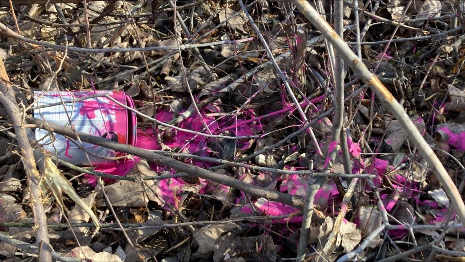 A can of pink paint remained below the vandalized billboard on Tuesday morning.