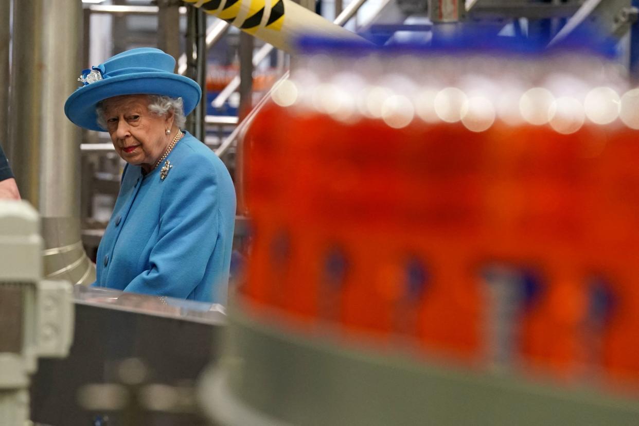 Britain's Queen Elizabeth II tours the production line during a visit to AG Barr's factory in Cumbernauld, east of Glasgow, where the Irn-Bru drink is manufactured on June 28, 2021. - The Queen is in Scotland for Royal Week where she will be undertaking a range of engagements celebrating community, innovation and history. (Photo by Andrew Milligan / POOL / AFP) (Photo by ANDREW MILLIGAN/POOL/AFP via Getty Images)