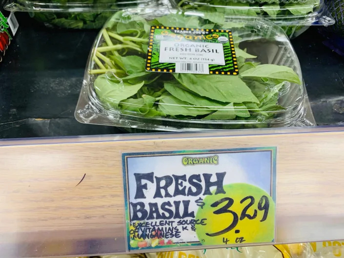 clear container of Trader Joe's fresh basil on shelf