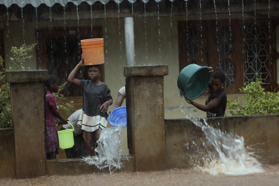 A family desperately scoop water from their flooded home, in Natite neighbourhood, in Pemba, on the northeastern coast of Mozambique, Sunday, April, 28, 2019. Serious flooding began on Sunday in parts of northern Mozambique that were hit by Cyclone Kenneth three days ago, with waters waist-high in areas, after the government urged many people to immediately seek higher ground. Hundreds of thousands of people were at risk. (AP Photo/Tsvangirayi Mukwazhi)