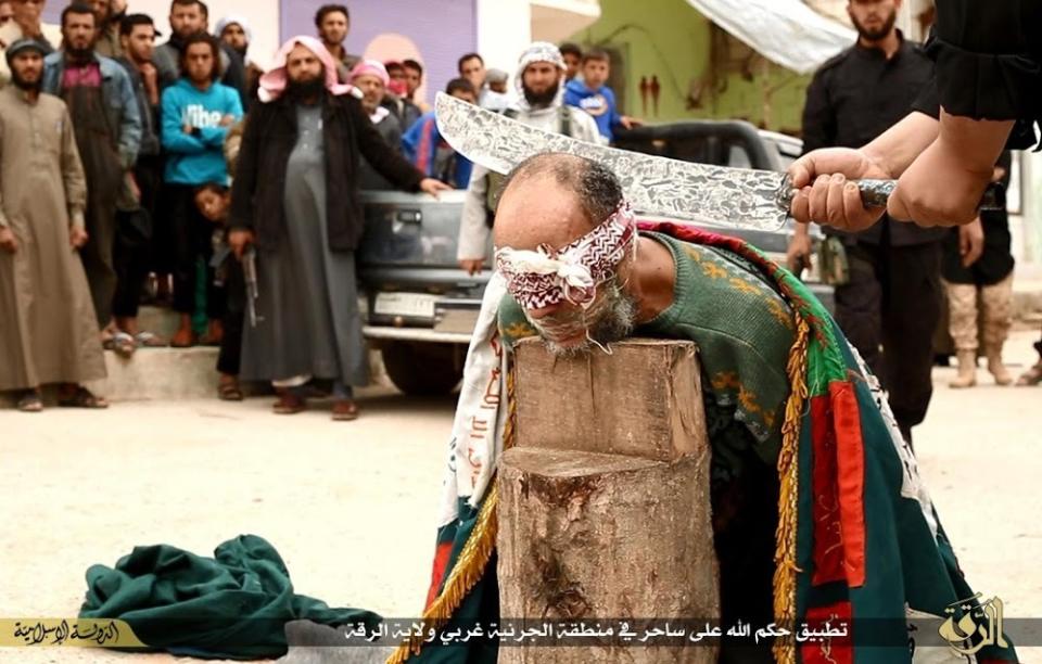 In this photo released on April 1, 2015, by a militant website, which has been verified and is consistent with other AP reporting, an Islamic State militant, not seen, right, holds a sword as he ready to beheads a Syrian magician, in Raqqa city, Syria. The Washington-based Syria Justice and Accountability Center, a U.S.-based Syrian rights group, said Thursday, Jan. 16, 2020, that evidence, documents produced by the Islamic State militants themselves, could help identify individuals responsible for atrocities during the militants four-year reign of terror in Syria, thus enabling prosecution for international crimes. (Militant website via AP)