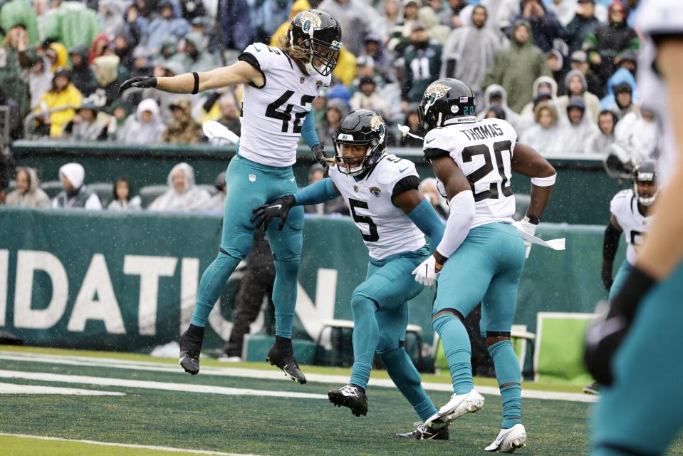 Jacksonville Jaguars safety Andre Cisco (5) celebrates his interception return for a touchdown with Andrew Wingard (42) and Daniel Thomas (20) against the Philadelphia Eagles during the second quarter of an NFL football game, Sunday, Oct. 2, 2022, in Philadelphia. (AP Photo/Rich Schultz)