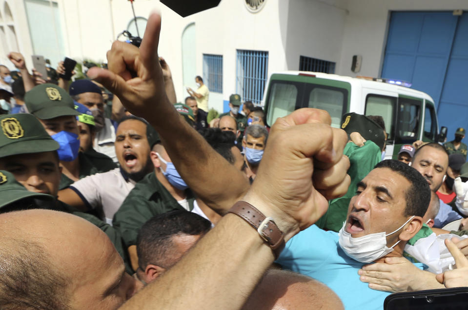 FILE - In this July 2, 2020 file photo, activist Karim Tabbou flashes a victory sign as he is greeted by supporters as he is released from the prison of Kolea, west of Algiers. A politician and a journalist who are prominent opposition figures in Algeria have been arrested days ahead of the country's parliamentary election, according to a group of lawyers defending jailed activists of the pro-democracy movement. The National Committee for the Liberation of the Detained said politician Karim Tabbou was arrested Thursday night at his home in the southwestern suburbs of Algiers. (AP Photo/Anis Belghoul, FILE)
