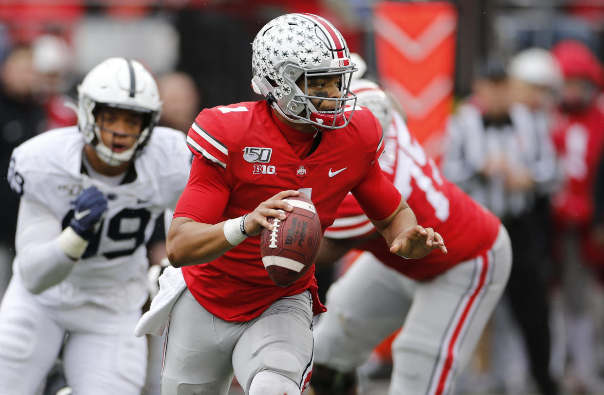 Ohio State quarterback Justin Fields, right, looks for an open receiver as Penn State defensive lineman Yetur Gross-Matos chases him during the second half of an NCAA college football game Saturday, Nov. 23, 2019, in Columbus, Ohio. Ohio State beat Penn State 28-17. (AP Photo/Jay LaPrete)