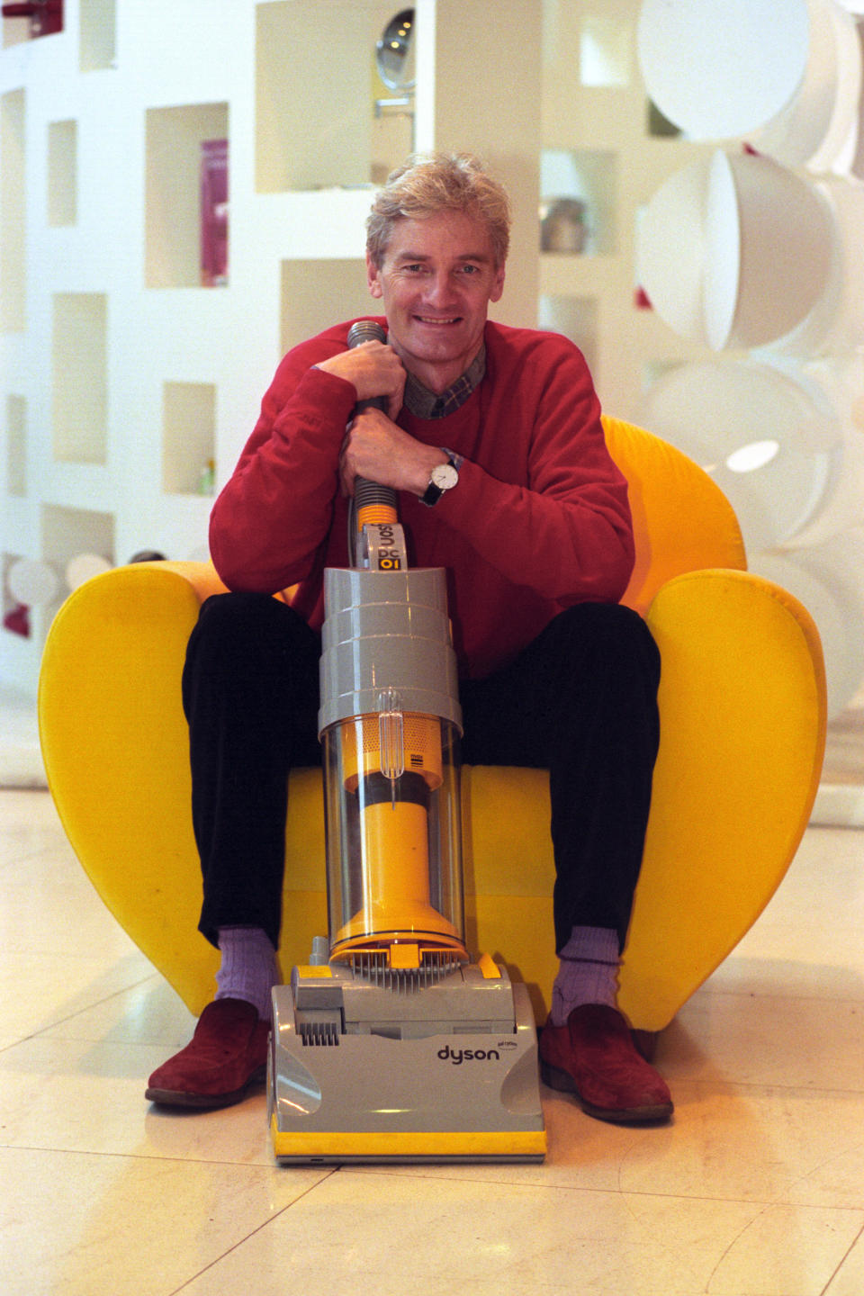 James Dyson,with his revolutionary design of vacuum cleaner, following the news that he is to receive a CBE for services to industrial design, in the New Year's Honours list. * 13/10/00: The High Court in London grants Dyson Appliances an injunction banning further sales of the Hoover Triple Vortex, until his patent runs out in June 2001. Dyson, inventor of the bagless Dual Cyclone machine, won a ruling on October 3 2000 that Hoover's bagless model infringed his copyright. 05/02/02 Electrical goods firm Dyson is to transfer manufacturing of its vacuum cleaners from Malmesbury, Wiltshire, to the Far East with the loss of up to 800 jobs, the company said. 5/10/03: Vacuum cleaners and washing machines are about to undergo another revolution at the hands of the British inventor - by learning to talk. Mr Dyson, who pioneered the cyclonic bagless vacuum cleaner, is working on a system that allows faulty appliances to 'speak' on the phone to help centres. The aim is to take the hassle out of giving information to call centre staff when machines break down.