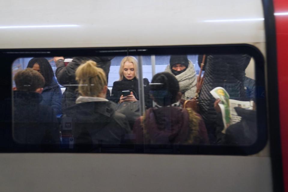 Passengers sit on a Jubilee line underground train at Canning Town station  (PA)