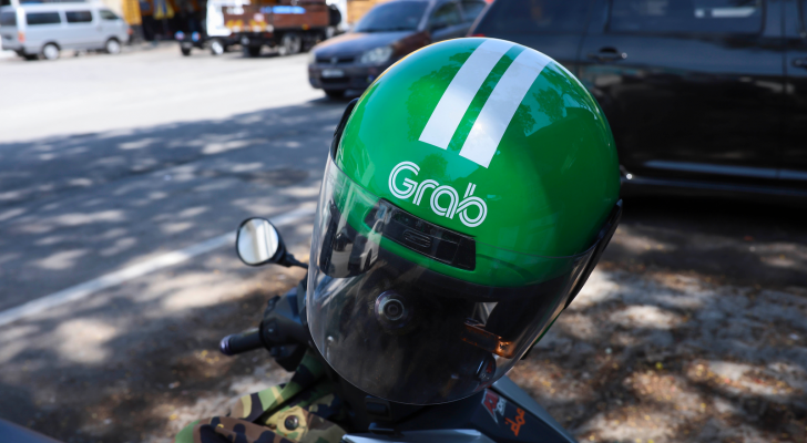 Motorcycle helmet with Grab logo on a motorcycle parked at the road side