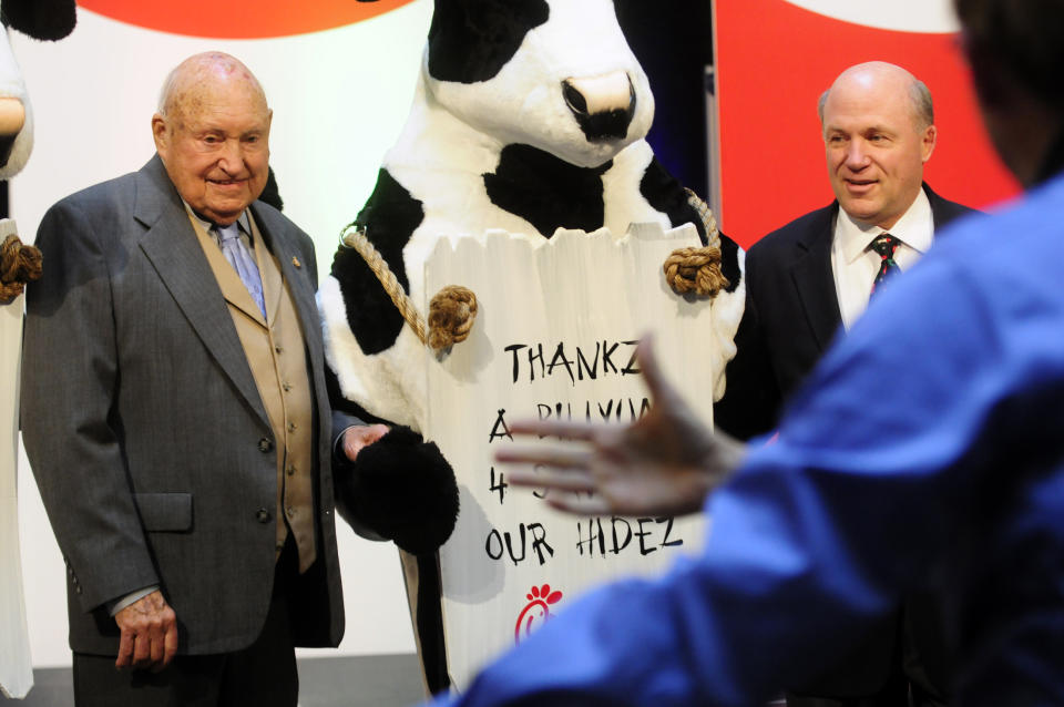 In this Monday, Dec. 14, 2009 picture, Chick-fil-a founder Truett Cathy, left, and his son Dan Cathy pose for a photo with the Chick-fil-A cows during a celebration of passing the $3 billon dollar mark in system-wide sales for the first time at the Chick-fil-a headquarters in Atlanta. Chick-fil-A, whose founder distinguished the fast-food chain by closing on Sunday out of religious piety, continues to mix theology with business and finds itself on the front lines of the nation’s culture wars after its president, Dan Cathy, confirmed his opposition to gay marriage in June 2012. (AP Photo/Atlanta Journal-Constitution, Elissa Eubanks)