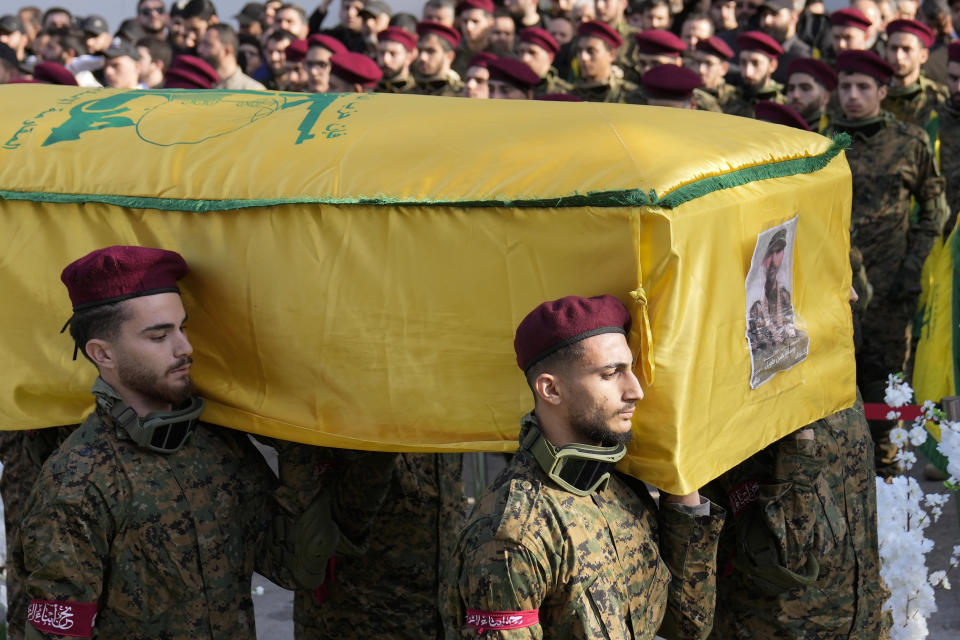 FILE - Hezbollah fighters carry the coffin of senior Hezbollah commander Wissam Tawil, during his funeral procession in the village of Khirbet Selm, south Lebanon, Tuesday, Jan. 9, 2024. A war of words that has unfolded in Lebanon show longstanding schisms in the small country over Hezbollah, now amplified by the militant group's role in the Lebanon-Israel border clashes and by fears that an already crisis-hit Lebanon could be dragged into an all-out war.(AP Photo/Hussein Malla, File)