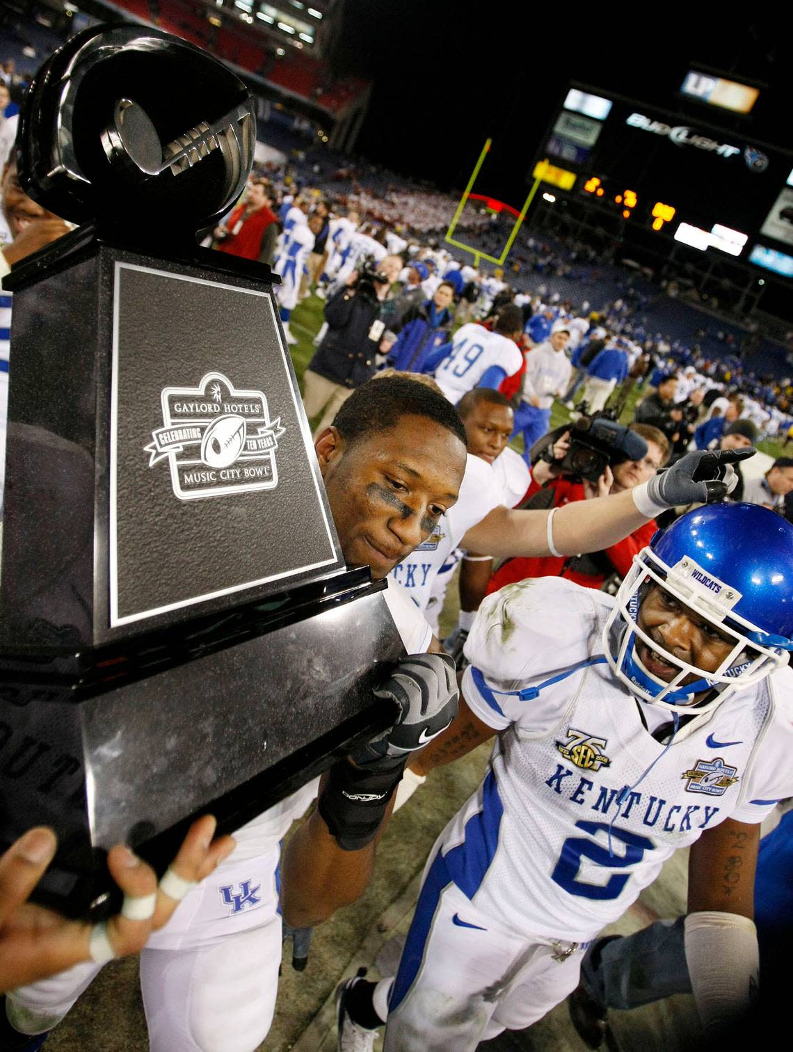 Kentucky wide receiver Keenan Burton, left, carries off the trophy as safety Marcus McClinton (2) looks on after their team defeated Florida State 35-28 in the Music City Bowl in Nashville on Dec. 31, 2007.