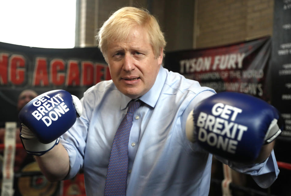 MANCHESTER, ENGLAND - NOVEMBER 19: Britain's Prime Minister Boris Johnson poses for a photo wearing boxing gloves emblazoned with "Get Brexit Done" during a stop in his General Election Campaign trail at Jimmy Egan's Boxing Academy on November 19, 2019 in Manchester, England. Britain goes to the polls on Dec.12. (Photo by Frank Augstein - WPA Pool/Getty Images)