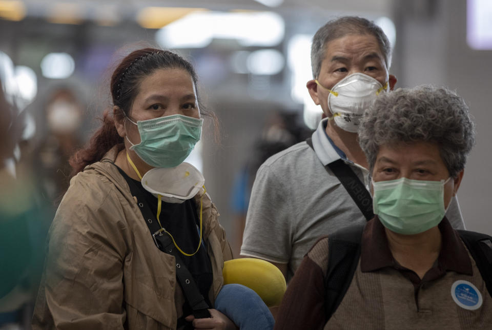 Tourists from Wuhan, China, some with double face masks, stand in a line for a charter flight back to Wuhan at the Suvarnabhumi airport, Bangkok, Thailand, Friday, Jan. 31, 2020. A group of Chinese tourists who have been trapped in Thailand since Wuhan was locked down due to an outbreak of new virus returned to China on Friday. (AP Photo/Gemunu Amarasinghe)