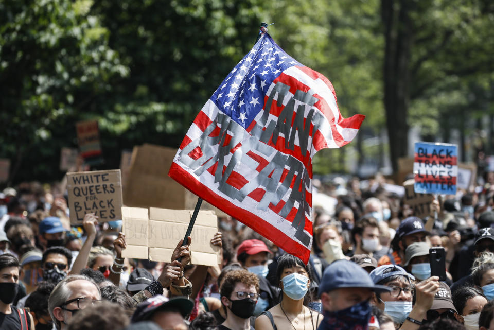 A protester waves an American flag with a message that reads "CAN'T BREATHE" during a memorial for George Floyd at Cadman Plaza Park in the Brooklyn borough of New York, on Thursday, June 4, 2020. Floyd, an African American man, died on May 25 after a white Minneapolis police officer pressed a knee into his neck for several minutes even after he stopped moving and pleading for air. (AP Photo/John Minchillo)