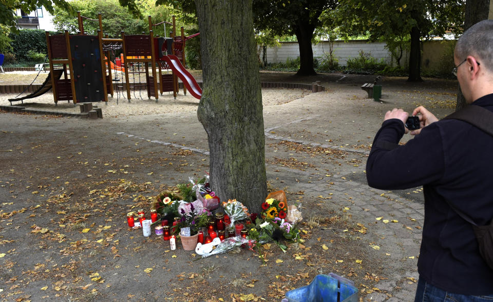 A man takes a picture at the site of a deadly brawl in Koethen, 90 miles southwest of the German capital Berlin, Sunday, Sept. 9, 2018. Police has arrested two Afghan men on suspicion of murder in the killing of a 22-year-old German man. (AP Photo/Jens Meyer)