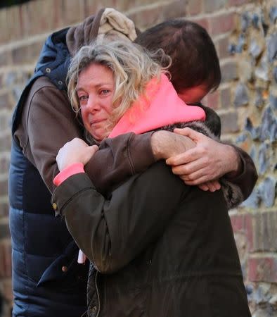 A man and a woman react outside the house of singer George Michael, where he died on Christmas Day, in Goring, southern England, Britain December 26, 2016. REUTERS/Eddie Keogh