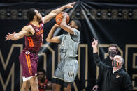 Virginia Tech guard Wabissa Bede (3) fouls Wake Forest guard Daivien Williamson (4) on a three point-attempt as Virginia Tech head coach Mike Young looks during an NCAA college basketball game Sunday, Jan. 17, 2021, in Winston-Salem, N.C. (Andrew Dye/The Winston-Salem Journal via AP)