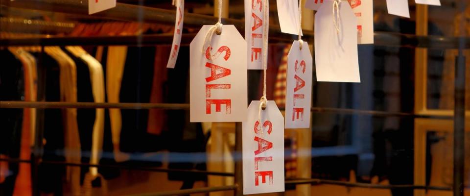 Sale labels hanging in a clothing store as concept of offering products at reduced prices.