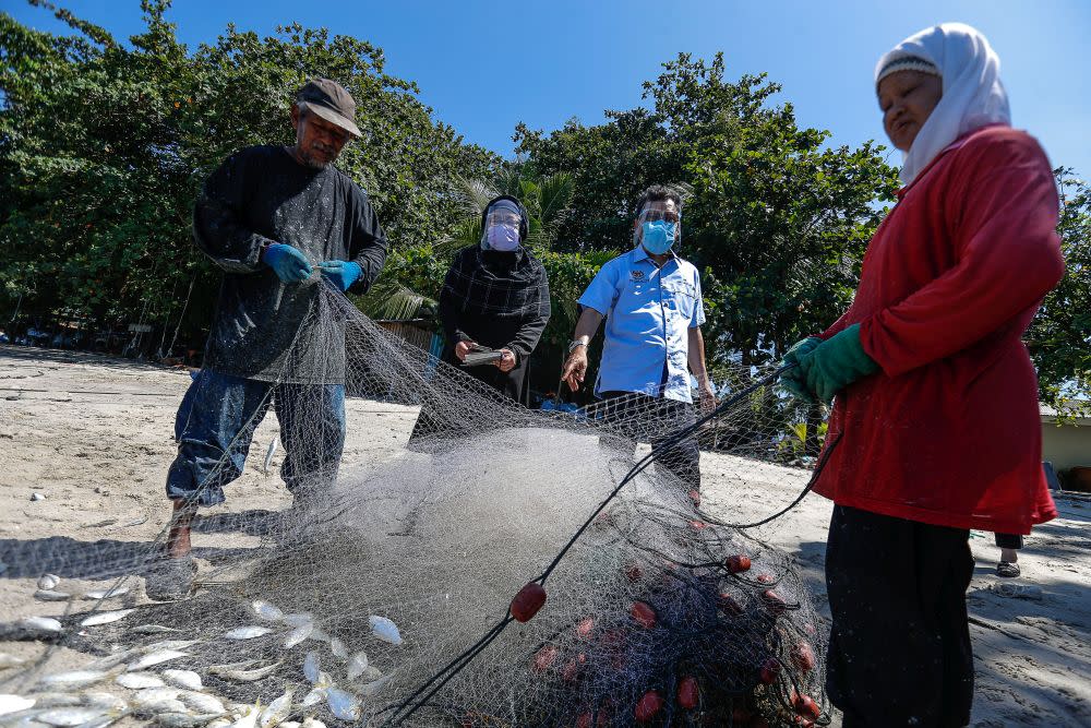 Deputy Agriculture and Food Industry Minister II Datuk Che Abdullah Mat Nawi (second from right) speaks to fisherfolk during a visit to Bayan Lepas June 16, 2021. — Picture by Sayuti Zainudin