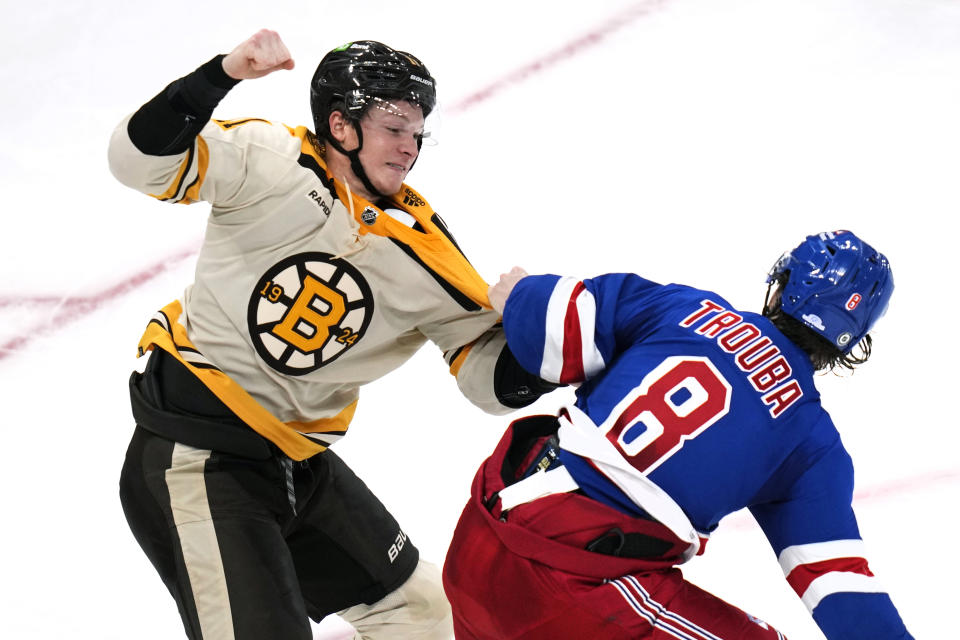 Boston Bruins center Trent Frederic, left, fights New York Rangers defenseman Jacob Trouba (8) during the second period of an NHL hockey game, Saturday, Dec. 16, 2023, in Boston. (AP Photo/Charles Krupa)