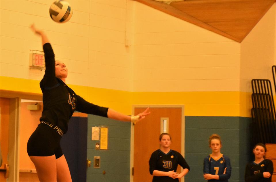 Paige Korosec prepares to serve for Mt. Markham with teammates looking on during Monday's match against Sauquoit Valley. The Mustangs trailed 20-18 in the third game when they sided out on a block by Korosec who then served the final six points and completed a three-game sweep with an ace in her final serve.