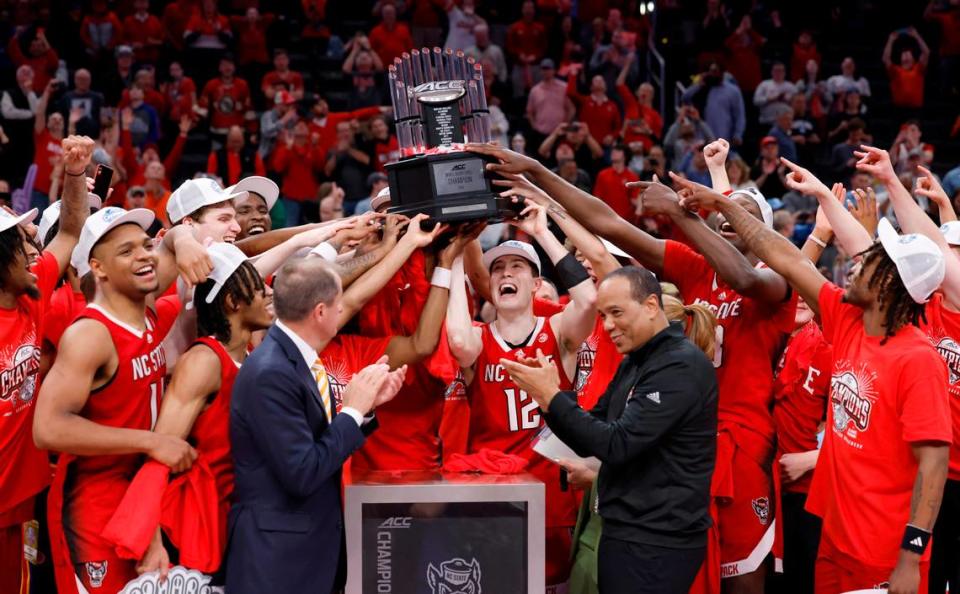 The N.C. State team raises the championship trophy after the Wolfpack’s 84-76 victory over UNC in the championship game of the 2024 ACC Men’s Basketball Tournament at Capital One Arena in Washington, D.C., Saturday, March 16, 2024.