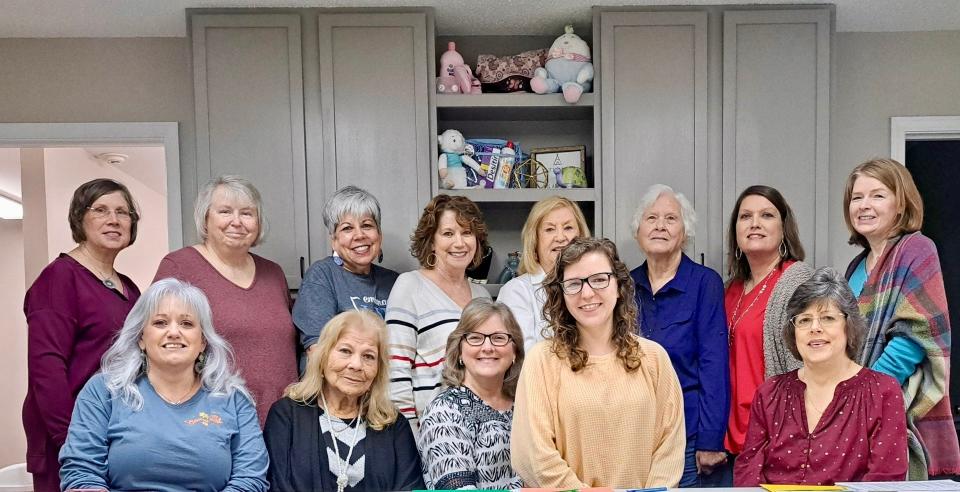 Staff and volunteers stand in front of baby store items collected at Alpha Women's Resource Center in Jackson, Alabama, in 2023.