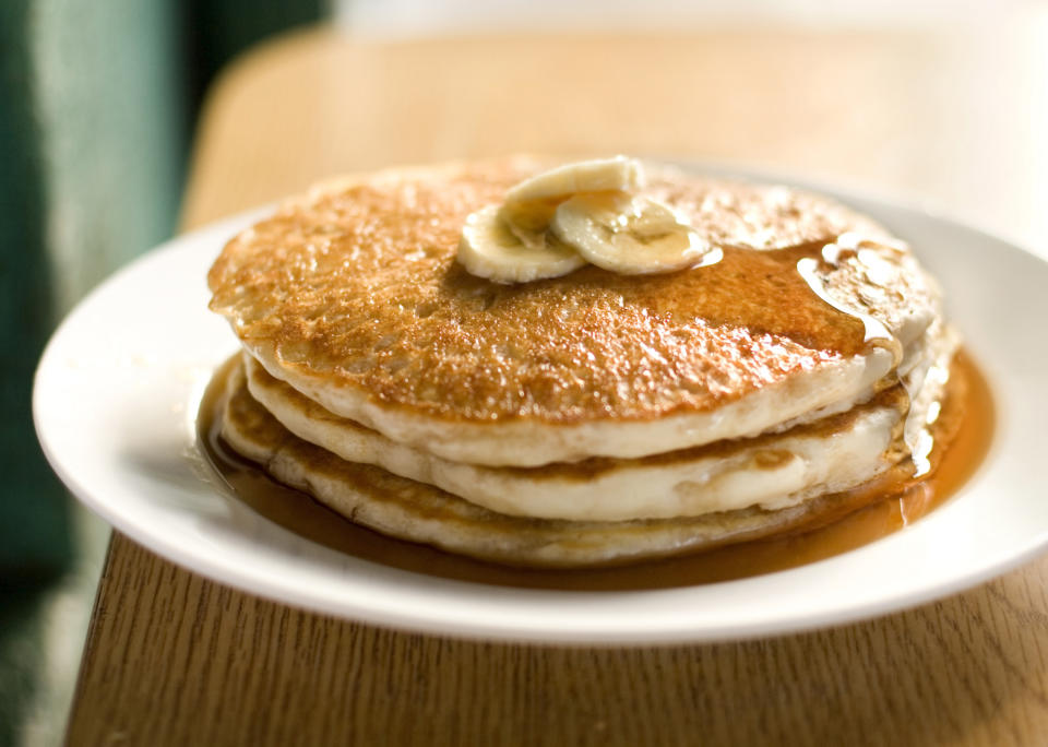 A stack of pancakes with butter and syrup on a plate