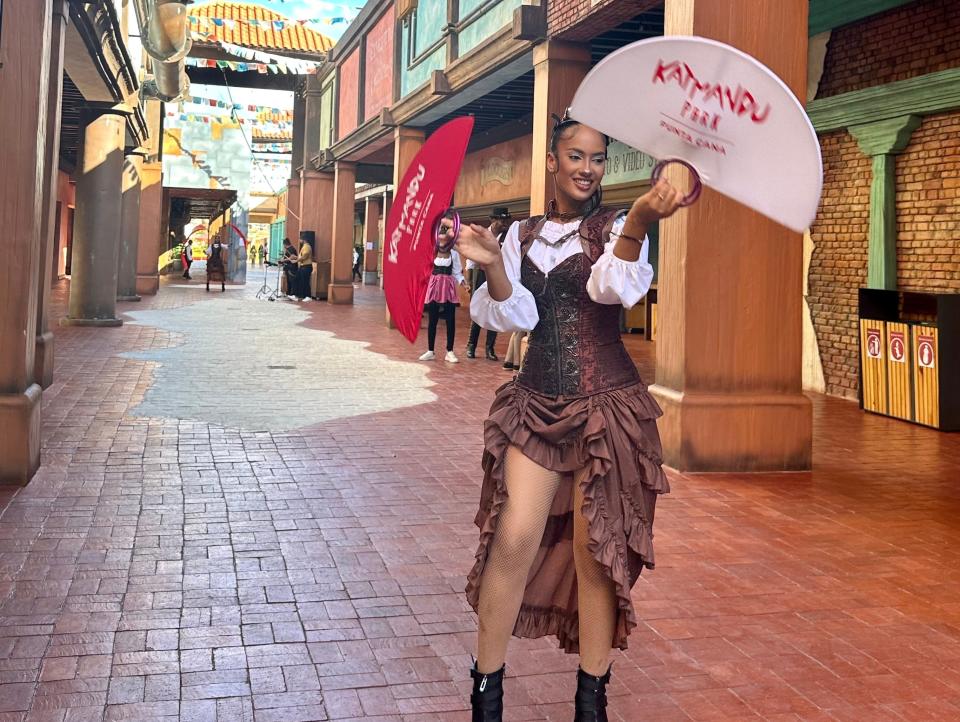 person in dress with fan dancing in alley