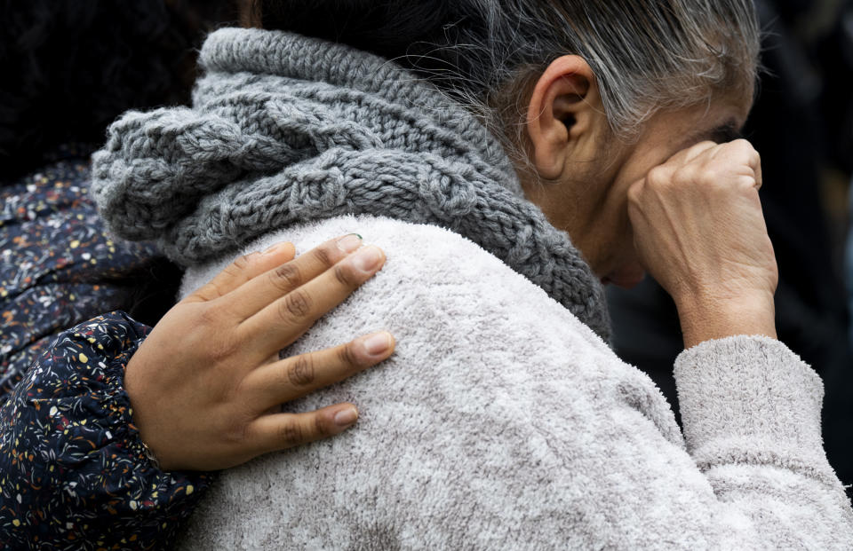 Community members mourn in front of the Patterson Park Observatory during a prayer circle in honor of the victims of the collapse of the Francis Scott Key Bridge, in Baltimore, Thursday, March 28, 2024. The prayer circle was hosted by Redemption City Church. (Kaitlin Newman/The Baltimore Banner via AP)