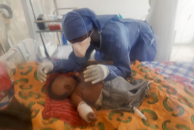 FILE PHOTO: Ebola survivor and caregiver Vianey Kombi takes care of a three-month-old orphan girl who is confirmed to be suffering from Ebola inside Ebola treatment center (ETC) in Beni