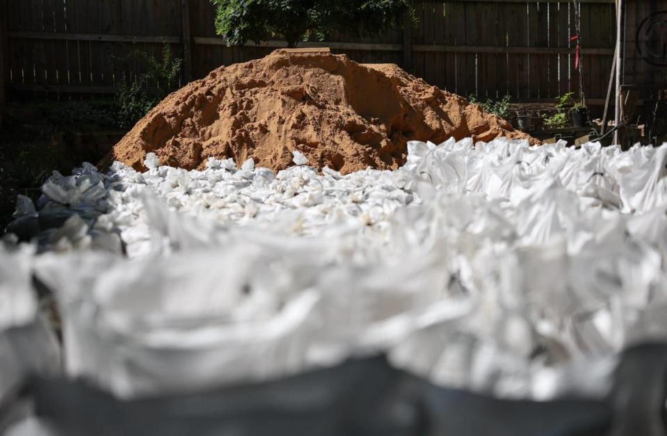 A large pile of sand and sandbags sit in Andrew Farnie’s backyard, ready to be filled as a preventative measure since his home has become a flood plain due to new development on his street.